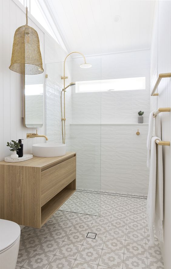 a tiny neutral bathroom with windows, a small shower space, a tiled floor, a floating vanity, a pendant lamp