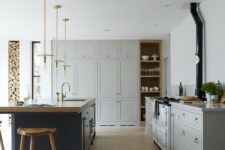 a traditional dove grey kitchen, a navy kitchen island with a wooden countertop and wooden stools to match it