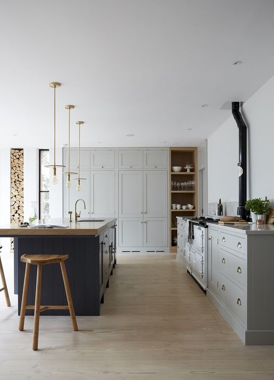 a traditional dove grey kitchen, a navy kitchen island with a wooden countertop and wooden stools to match it
