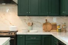 an elegant hunter green kitchen with a white marble backsplash and countertops and a white kitchen island for a contrast