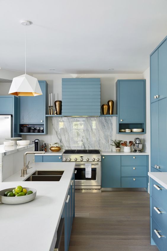 an ocean blue kitchen with white countertops, a white marble backsplash, a white geometric pendant lamp and white handles