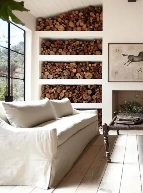 a non-working fireplace and an open storage unit with firewood make this Provence room cozy and welcoming