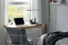 09 a small IKEA Scandinavian guest bedroom with a large bed, a lightweight stained desk, a grey chair and open shelves