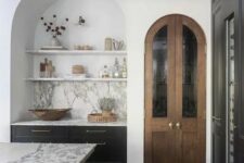 18 a contemporary kitchen with a large arched niche with built-in dark cabinets, open shelves and a marble backsplash is adorable