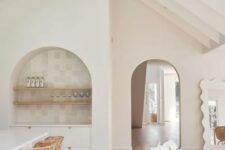 22 an airy neutral kitchen with a dining space, with an arched niche clad with neutral tiles, wooden shelves and a built-in sideboard is amazing