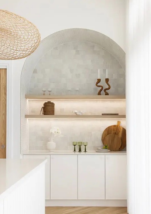 an arched niche with built-in cabinets, open lit up shelves with decor is a lovely idea that will let you store and display