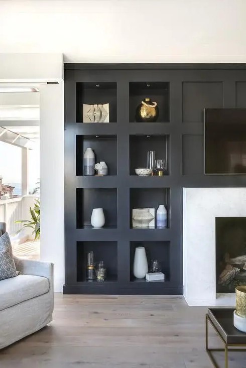 a modern living room featuring a fireplace and a series of niche shelves for displaying various decor