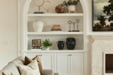 29 a neutral living room accented with an arched niche with decor, potted plants and artwork is a lovely idea for any space