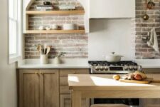30 a modern farmhouse kitchen with stained lower cabinets, a brick backsplash, an arched niche with shelves fro storage and display