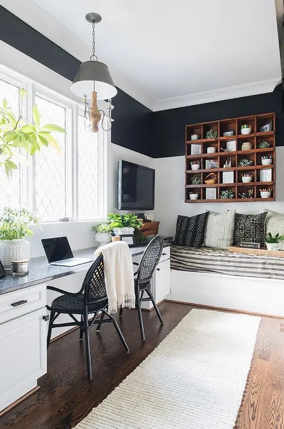 a black and white guest bedroom with white shiplap walls, a double desk and black chairs, a built-in bed, a TV and a stained shelving unit