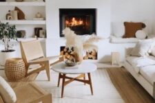 37 a neutral living room with built-in niche shelves and a seat, with a fireplace, a white sofa and woven chairs