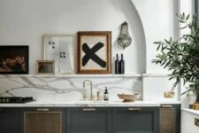 42 a stylish charcoal grey kitchen with a white marble backsplash and countertops, an arched niche with a ledge and a gallery wall in it