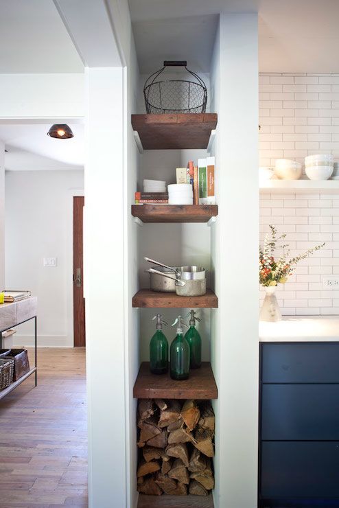 a tall and narrow niche with books used for firewood, books, decor and some cookware is awesome