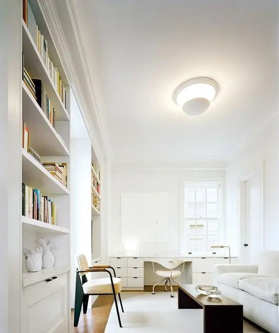 a very elegant space with a convertible sofa, bookcases and a large desk by the window
