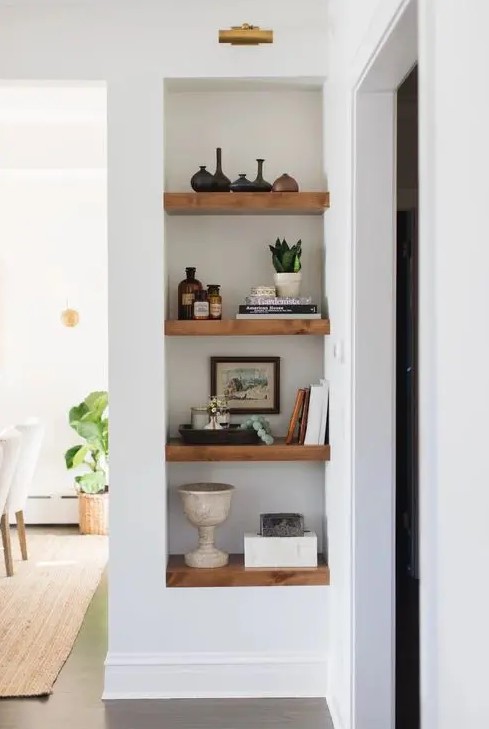 a niche with wooden shelves and additional light is a perfect way to style your awkward nook the best way possible