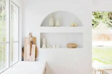 51 an airy white kitchen with an arched niche with beautiful tableware on display is a chic and lovely space