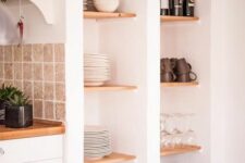 55 deep niches with wooden shelves and baskets that are used for storing dishes, glasses and plates and wine