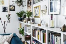 a Scandinavian living room with white crate bookshelves, a free form gallery wlal and potted plants plus lovely decor