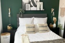 a boho neutral bedroom with a forest green accent wall, a grey bed and neutral bedding, a macrame, a gallery wall, a pendant lamp