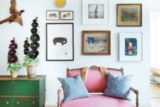 a catchy and bright space with a pink loveseat, a green sideboard, a free form gallery wall and some pretty decor