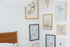 a catchy gallery wall covering the corner with blonde wood, white and black frames, white matting and some abstract art