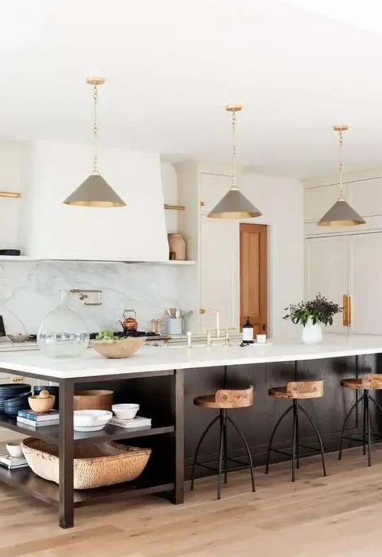 a chic farmhouse kitchen with white shaker style cabinets, a dark stained kitchen island with open shelves, grey pendant lamps
