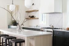 a chic modern farmhouse kitchen with black cabinets, a shiplap tan kitchen island, black stools and pendant lamps