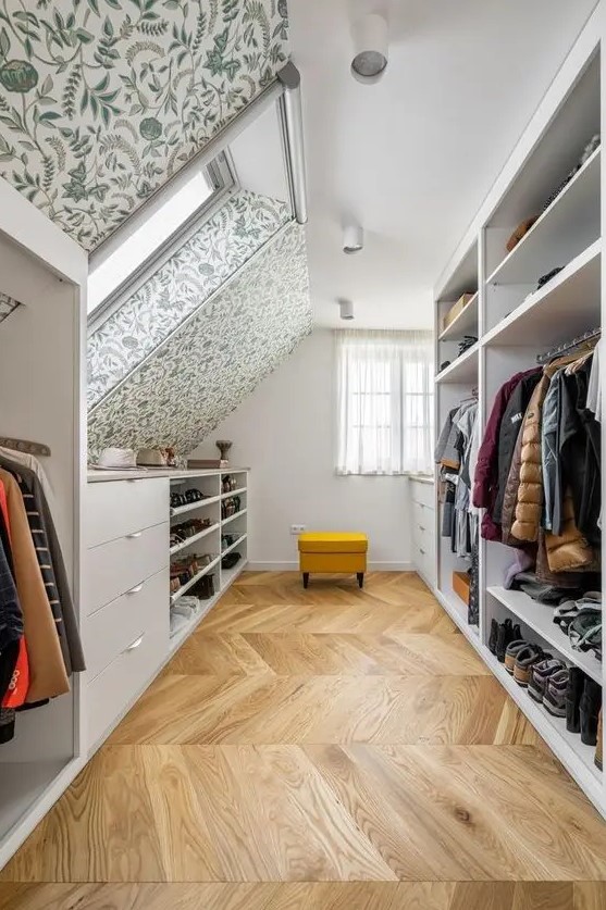 a cool attic closet with wallpaper walls and ceilings, dressers, open storage compartments and a yellow stool is a lovely space