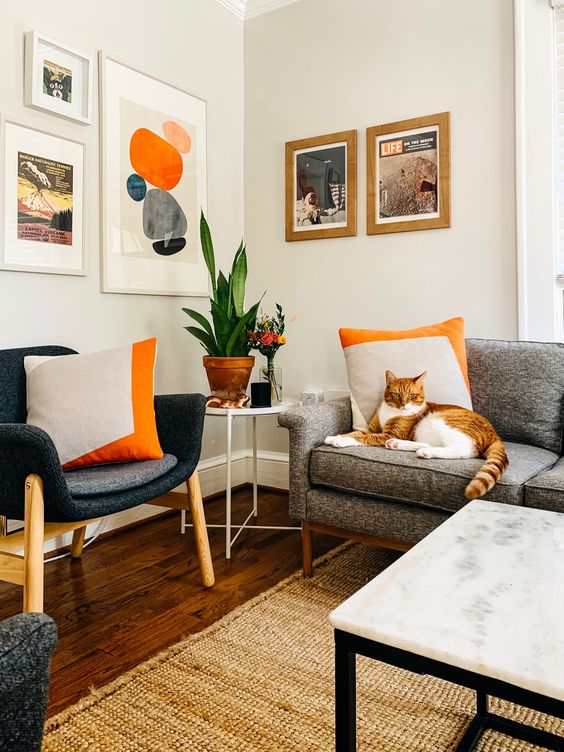 a cozy mid-century modern living room with a free form gallery wlal, a felt chair and a grey sofa, a marble coffee table