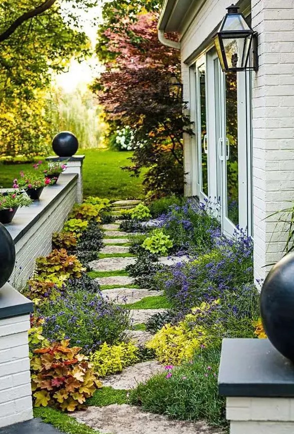 a floral side yard with an irregular stone path, bright blooms and greenery, potted plants and blooms around