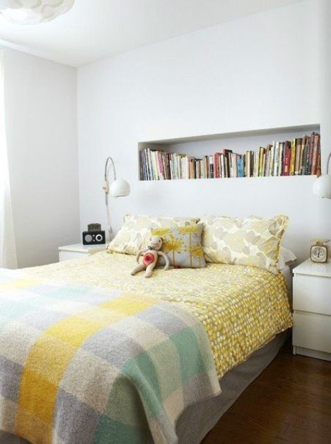 a kid's room with a niche as a bookshelf, a bed with bright bedding, nightstands and table lamps