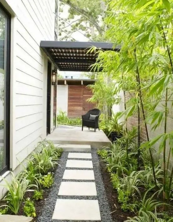 a low-maintenance side yard with pebbles, tiles, greenery and bamboo is a lovely idea for a modern home