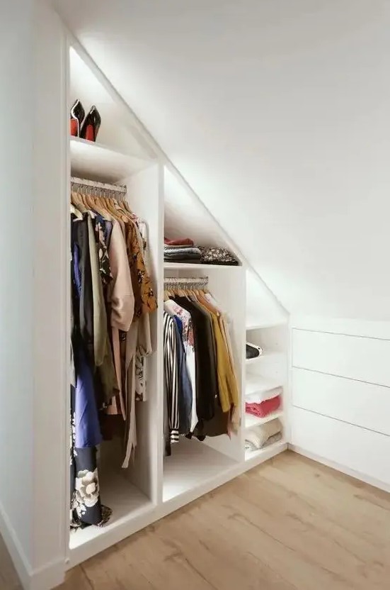 a minimalist white built-in closet with built-in lights and shelves is a cool solution for a small home, it's smart and cool