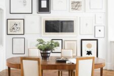 a modern and refined dining room with an oval table and neutral chairs, a floor to ceiling gallery wall with monochromatic artwork