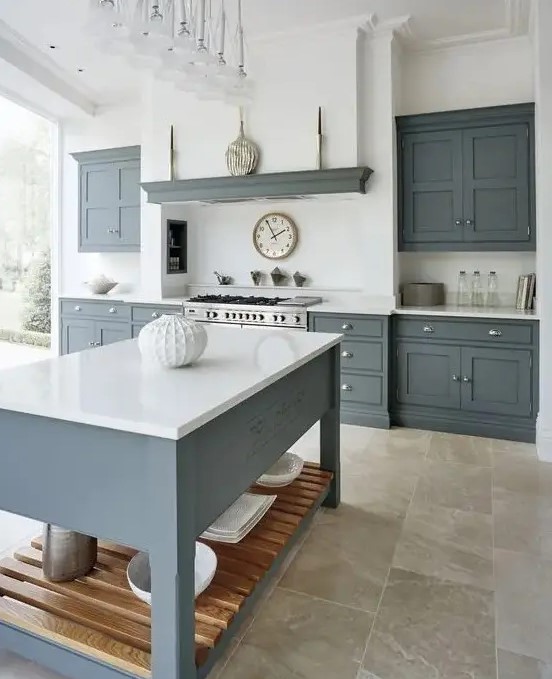 a modern country kitchen with graphite grey cabinets and a kitchen island, white countertops and a built-in hood plus a glazed wall