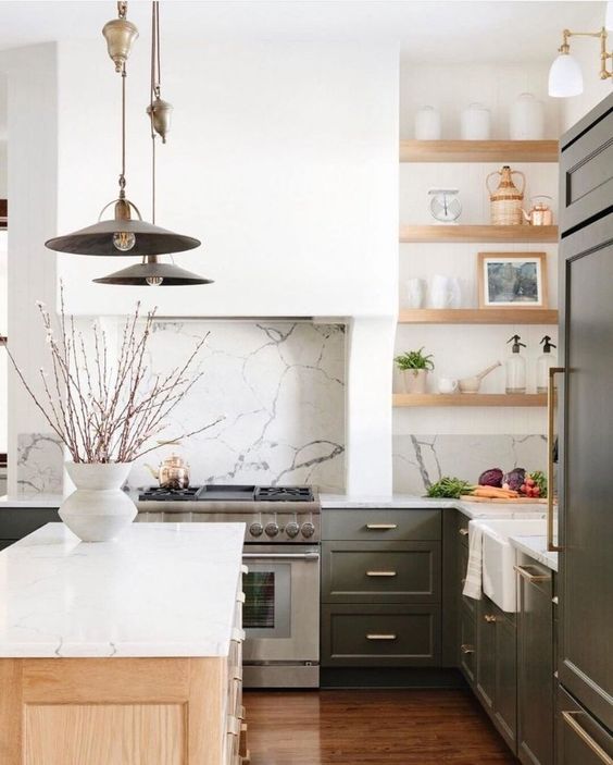 a modern farmhouse kitchen with green cabinets, stained shelves, a hood, a kitchen island, catchy pendant lamps