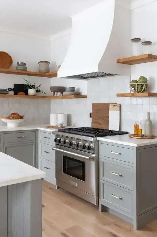 a modern farmhouse kitchen with grey shaker cabinets, white stone countertops, a zellige tile backsplash, open shelves