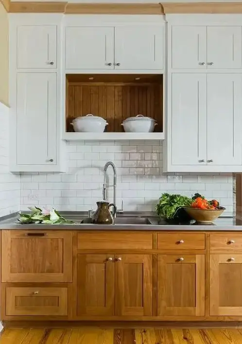 a modern farmhouse kitchen with lower stained cabinets, upper white ones, a white subway tile backsplash, a metal countertop for a cozy look and maximal functionality