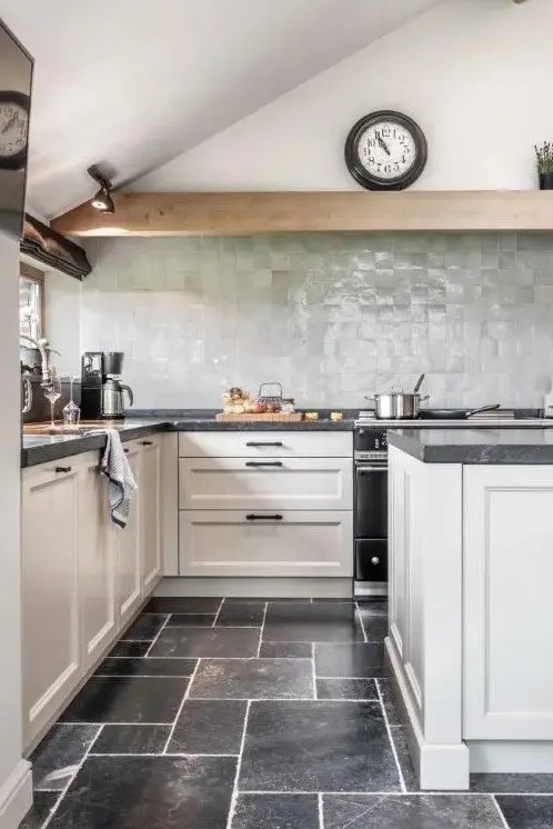 a modern farmhouse kitchen with neutral shaker cabinets, black stone countertops, a pale green zellige tile backsplash