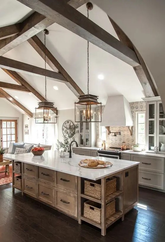 a modern farmhouse kitchen with white shaker style cabinets and a stained kitchen island, a printed tile backsplash and chic pendant lamps