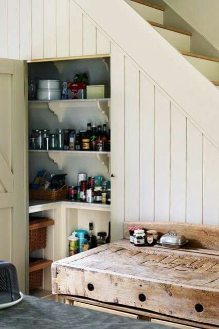 a modern farmhouse staircase clad with shiplap, with built-in and open shelves inside and some baskets for storage