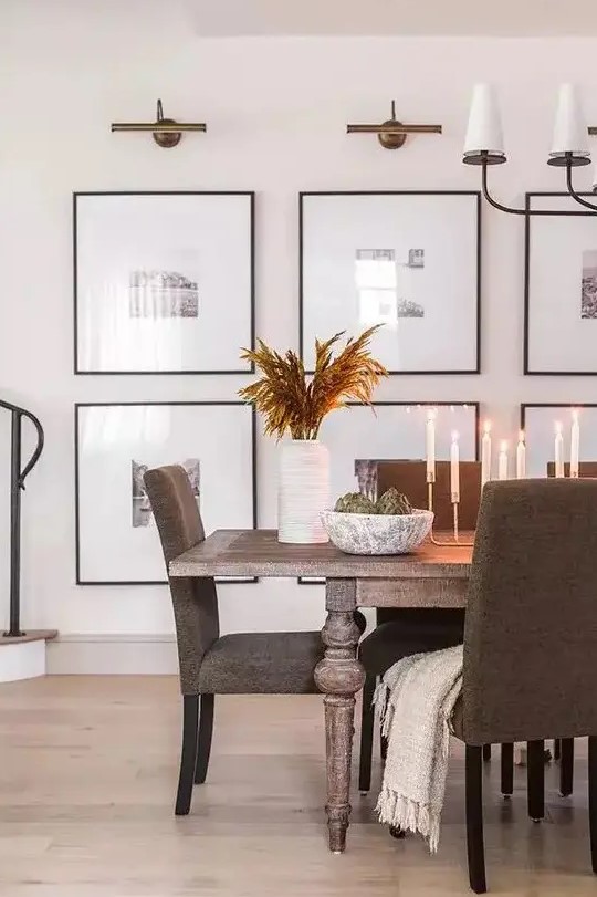 a modern gallery wall with black and white photos and with matching black frames is a very cool and stylish idea