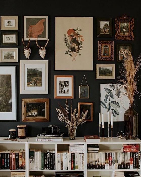 a moody gallery wall with mismatching frames but with the same theme, woodlands, and with antlers