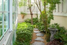 a peaceful and natural side yard with greenery, shrubs and trees plus a fountain and lovely stepping stones