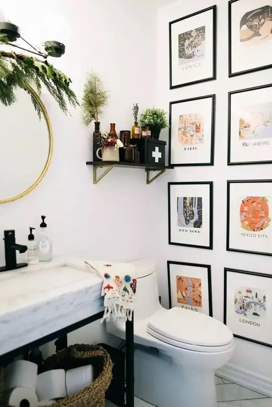 a pretty and lovely bathroom with a colorful gallery wall, a sink on a metal and stone vanity, greenery and apothecary bottles