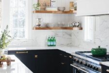 a pretty modern farmhouse kitchen with black lower cabinets and corner shelves, gold touches and a large hood