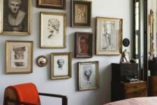 a refined gallery wall with gilded frames and vintage portraits and statue heads is a chic idea for a vintage space
