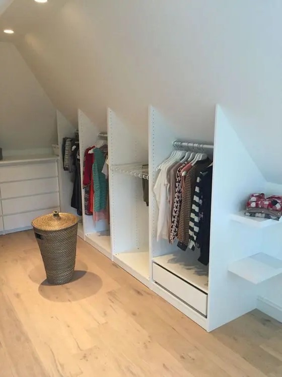 a simple and small Scandinavian attic closet with a dresser and open storage compartments that built into the attic nook
