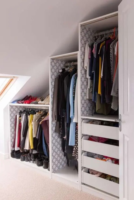 a slanted ceiling closet with open shelves and drawers and a skylight is a very cool and smart idea to rock