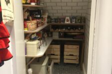 a small farmhouse pantry with subway and printed tiles, an open shelving system, crates and plastic boxes